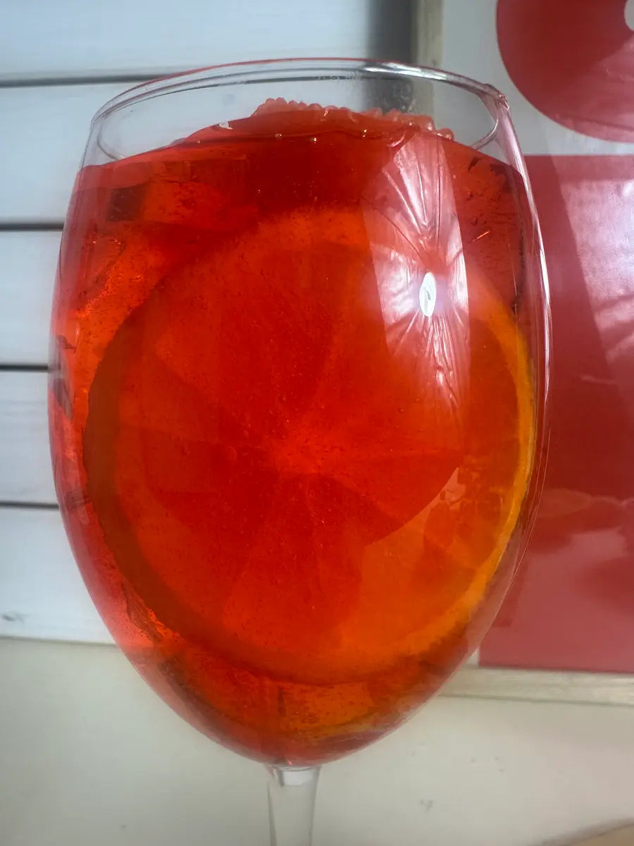 Nahaufnahme der Duftkerze Aperol Spritz mit leuchtendem Orangenduft und realistischer Glasoptik – kramMITcharme
