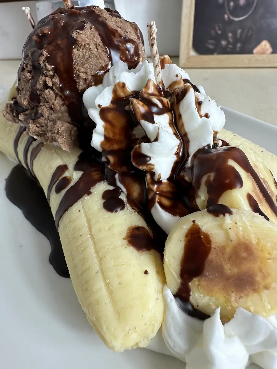 Nahaufnahme der Duftkerze Banana Split mit Banane, Schokosauce und cremiger Sahnehaube – kramMITcharme