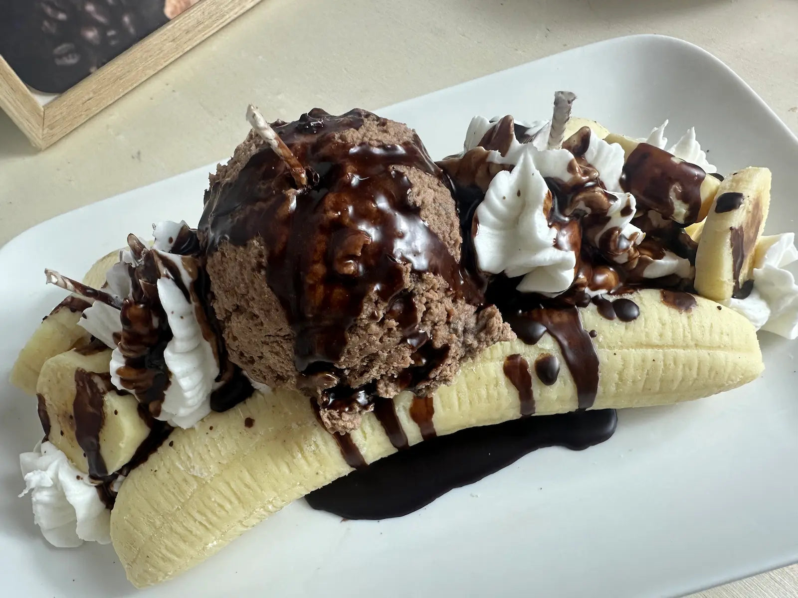 Detailaufnahme der Duftkerze Banana Split mit Schokoladenkugel, Sahne und Nüssen – kramMITcharme
