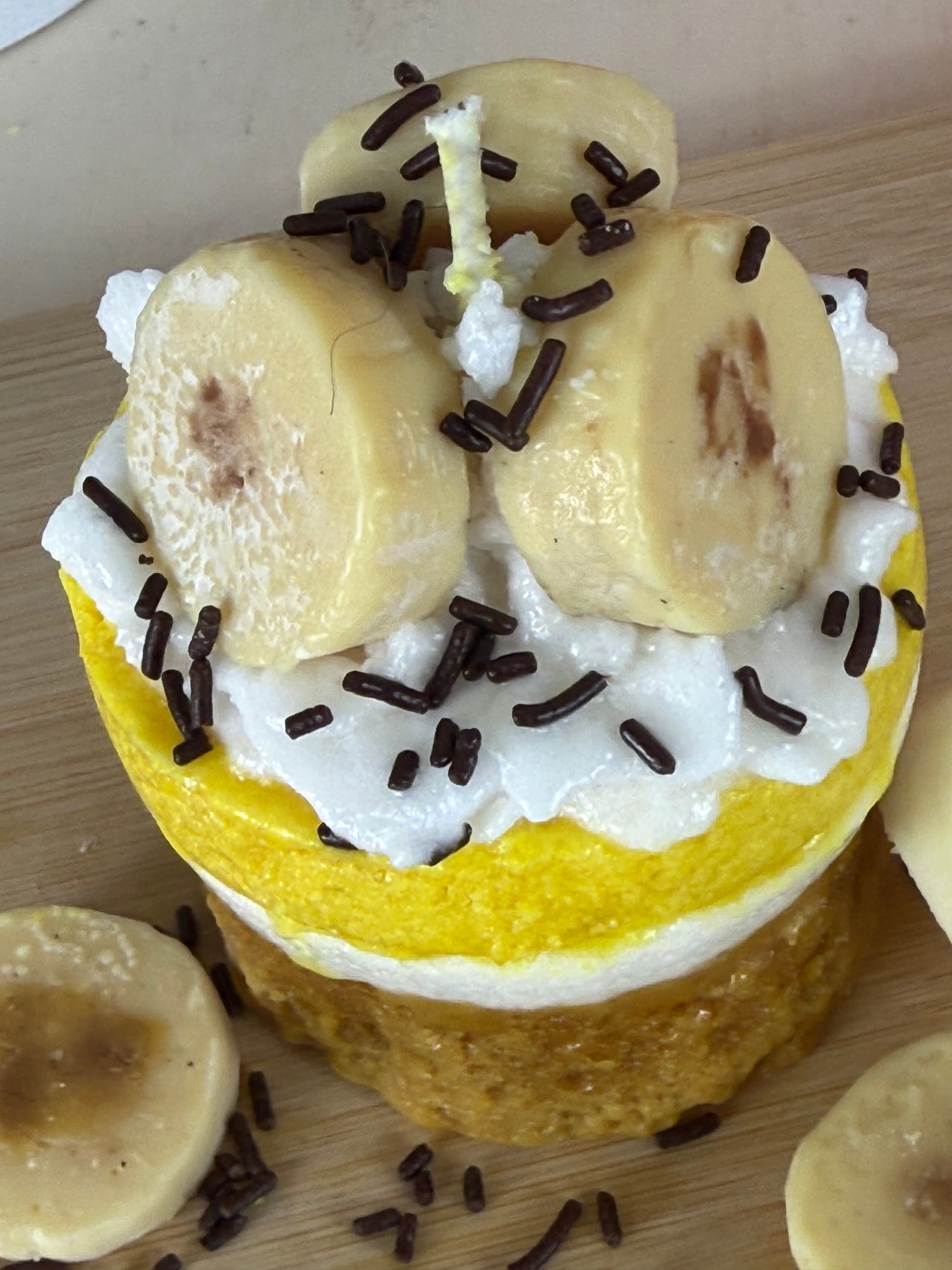 Nahaufnahme der handgegossenen Duftkerze Bananen Törtchen mit Banane und Schokostreuseln – kramMITcharme