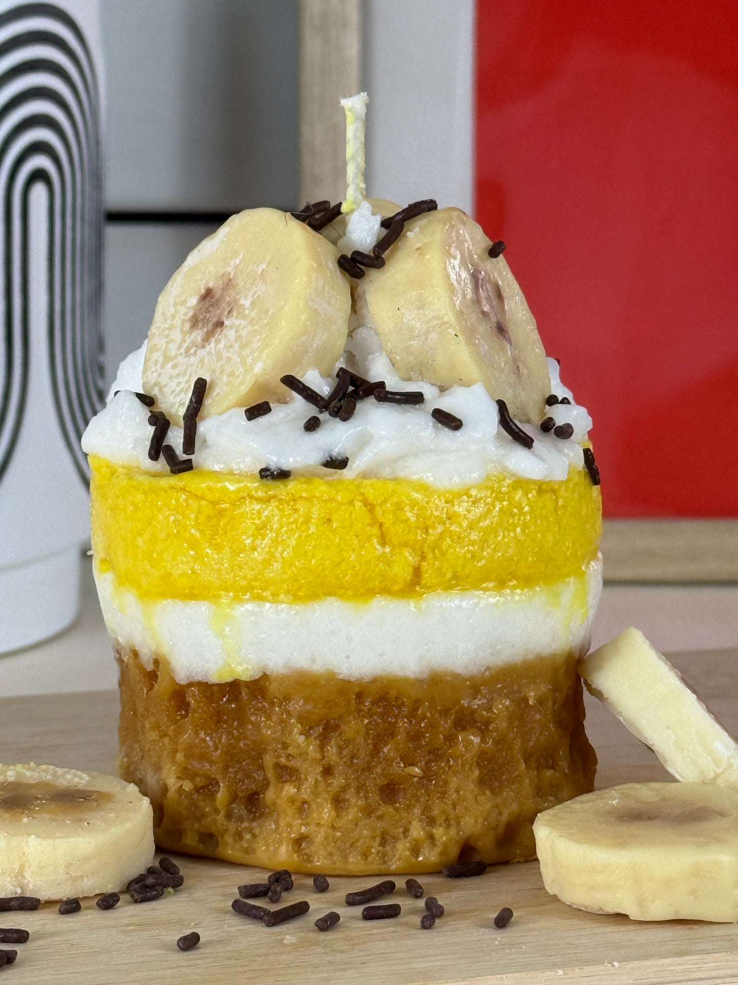 Seitenansicht der Duftkerze Bananen Törtchen mit gelbem Wachs, Sahnetopping und Banane – kramMITcharme