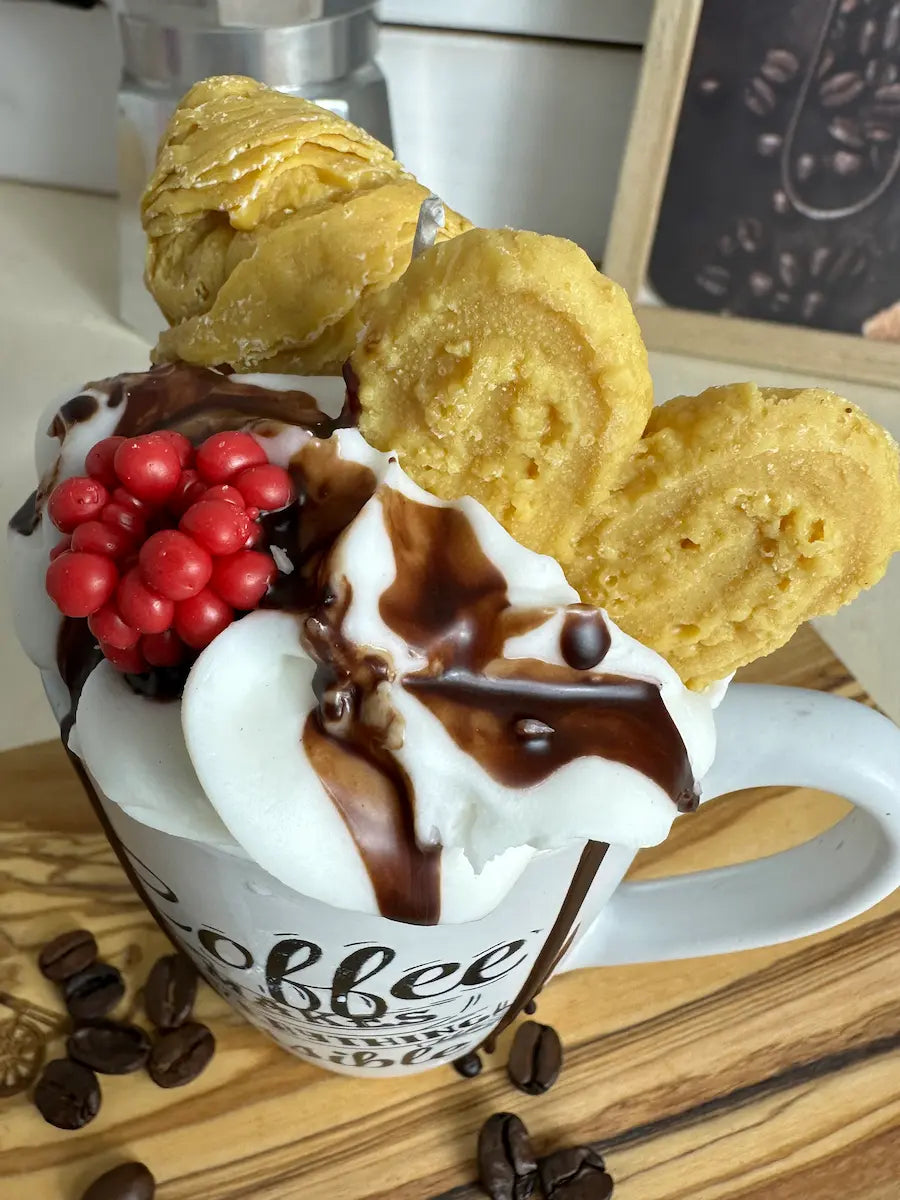 Schrägaufnahme der Duftkerze „Coffee Makes Everything Possible“ mit Keksen und cremigem Wachs – kramMITcharme