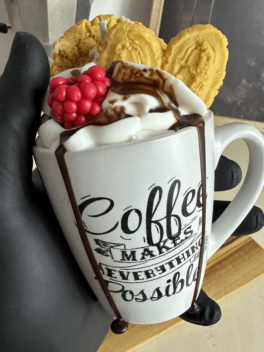 Handaufnahme der Duftkerze „Coffee Makes Everything Possible“ mit roten Beeren und Butterkeks – kramMITcharme
