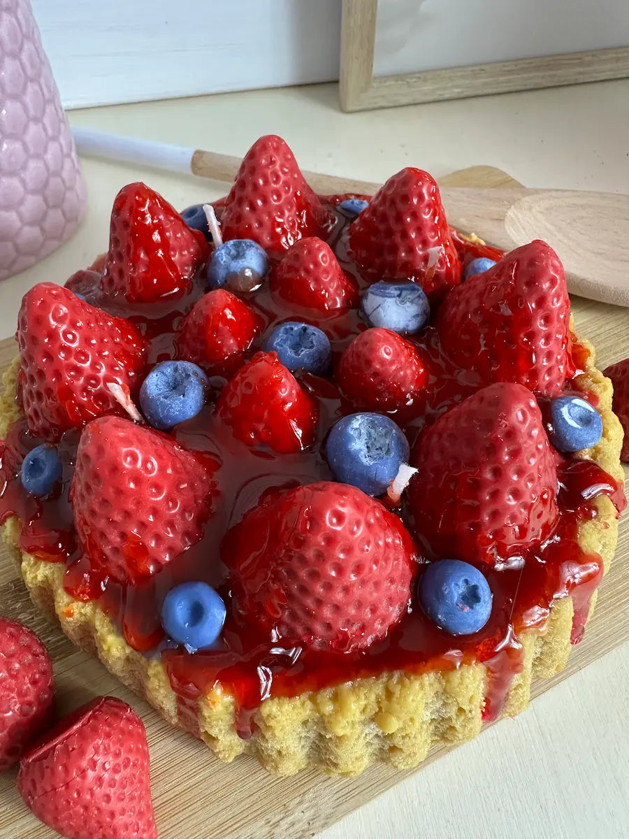 Obenaufnahme der Duftkerze „Erdbeerkuchen“ mit frischen Erdbeeren und Blaubeeren in realistischer Optik – kramMITcharme