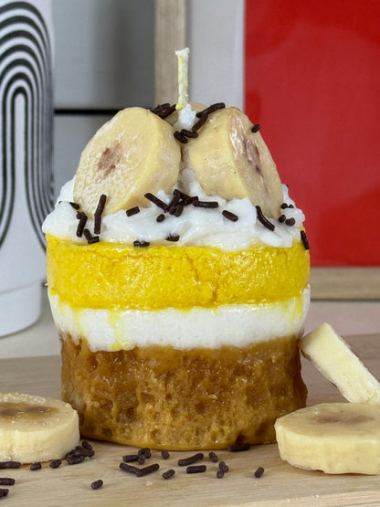 Seitenansicht der Duftkerze Bananen Törtchen mit gelbem Wachs, Sahnetopping und Banane – kramMITcharme
