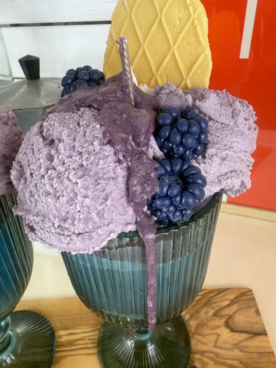 Detailansicht der Duftkerze Blueberry Beast mit violettem Wachs, Beeren und Waffel – kramMITcharme