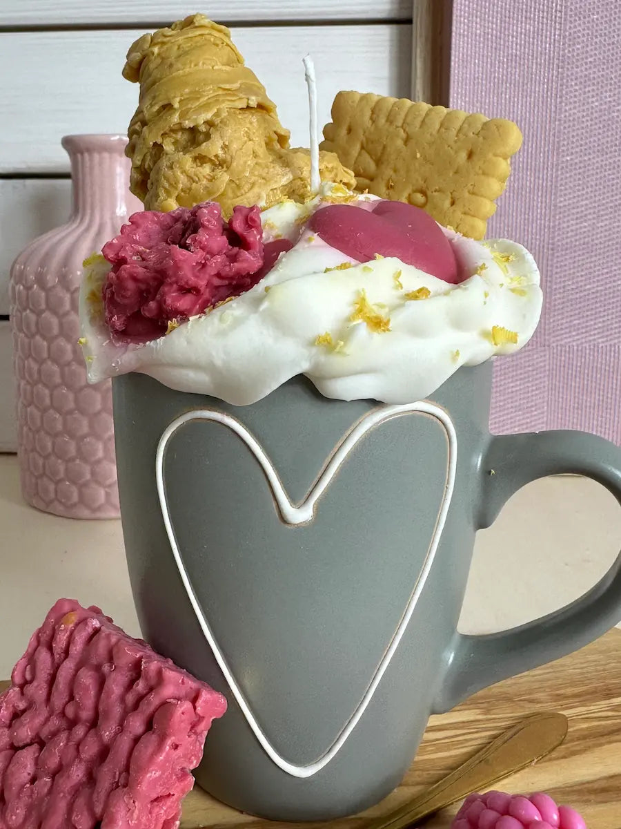 Nahaufnahme der Duftkerze „Coffee of Love“ mit rosa Herzdekor und Keksstück – kramMITcharme
