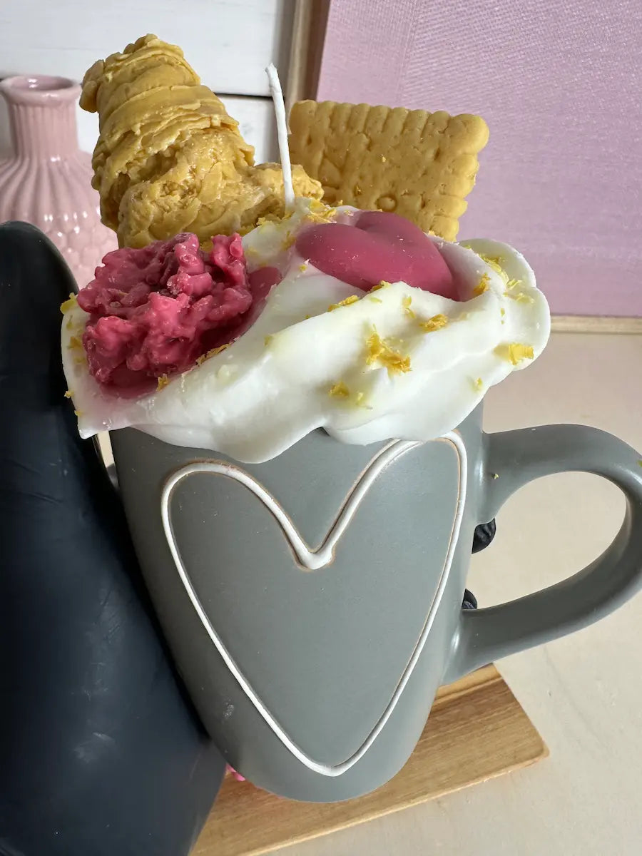 Handaufnahme der Duftkerze „Coffee of Love“ mit Herz-Topping und cremiger Wachsoptik – kramMITcharme