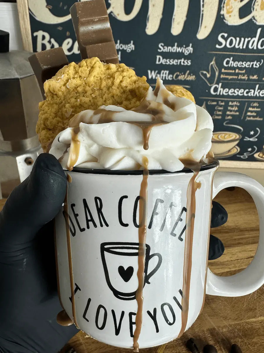 Handaufnahme der Duftkerze „Dear Coffee I Love You“ mit Schaum- und Keksdeko – kramMITcharme