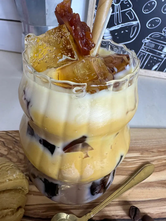 Nahaufnahme der Schichtkaffee-Kerze mit Milchschaumwachs, Karamell-Deko und Crisp-Elementen – kramMITcharme