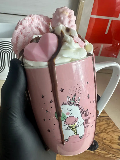 Handaufnahme der Duftkerze „Einhorn“ mit Tassenmotiv und cremiger Wachsdekoration – kramMITcharme