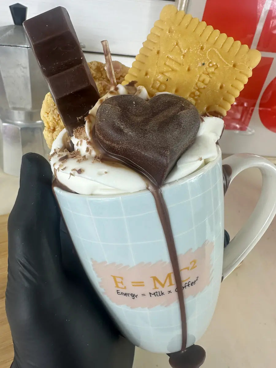 Handaufnahme der Duftkerze „Einsteins Coffeecup“ mit Herzschokolade und Wachscreme – kramMITcharme