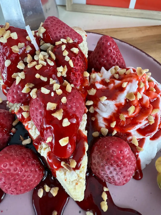 Detailaufnahme der Duftkerze „Erdbeer-Traum“ mit Erdbeersoße, Nussstückchen und realistischer Wachsstruktur – kramMITcharme