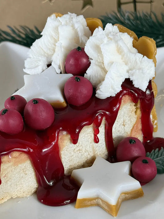 Nahaufnahme der Duftkerze „Glühwein-Cheesecake Deluxe“ mit roter Glühweinsoße, runden Glühweinbeeren und cremiger Baiserhaube im Cheesecake-Look – kramMITcharme