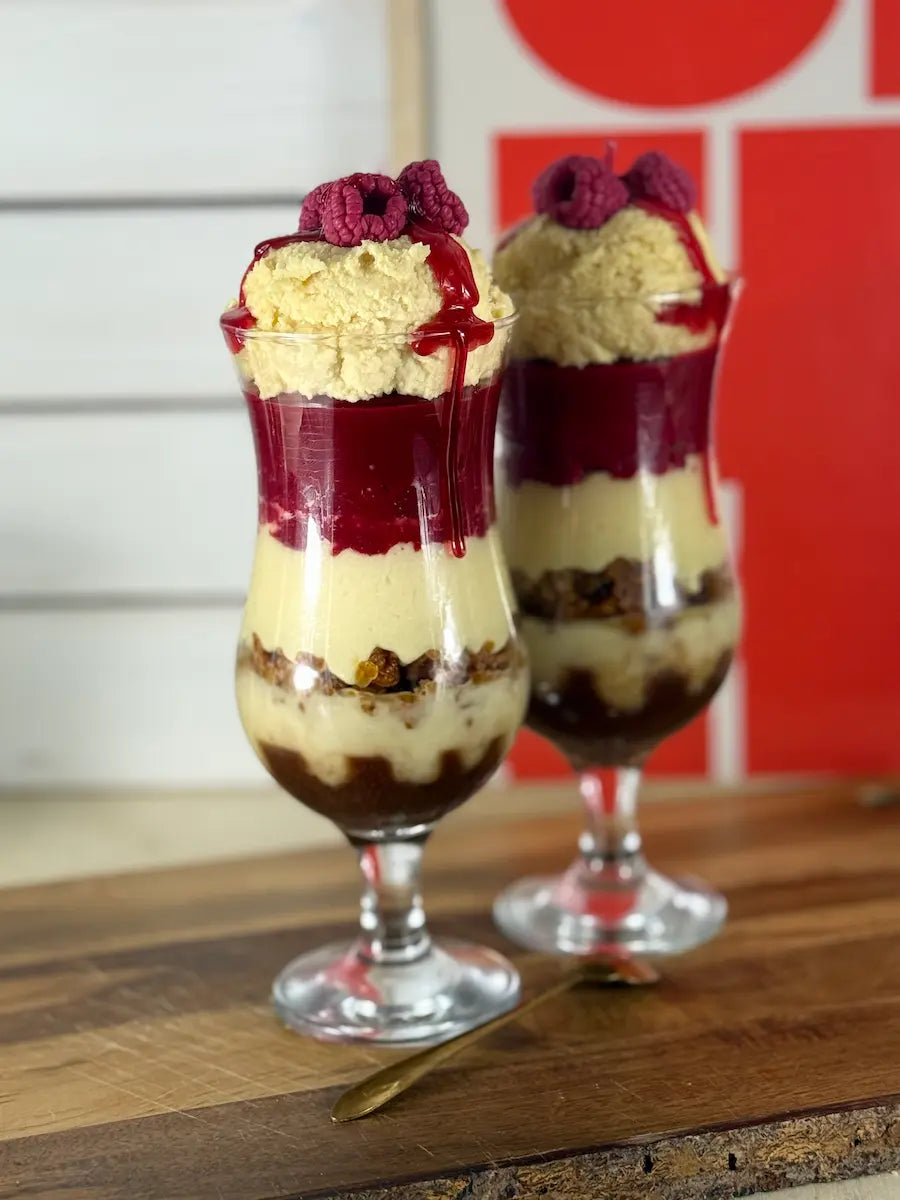 Handgemachte Dessertkerze im Glas mit Vanillecreme-Optik, Himbeerschichten und Keksboden – kramMITcharme