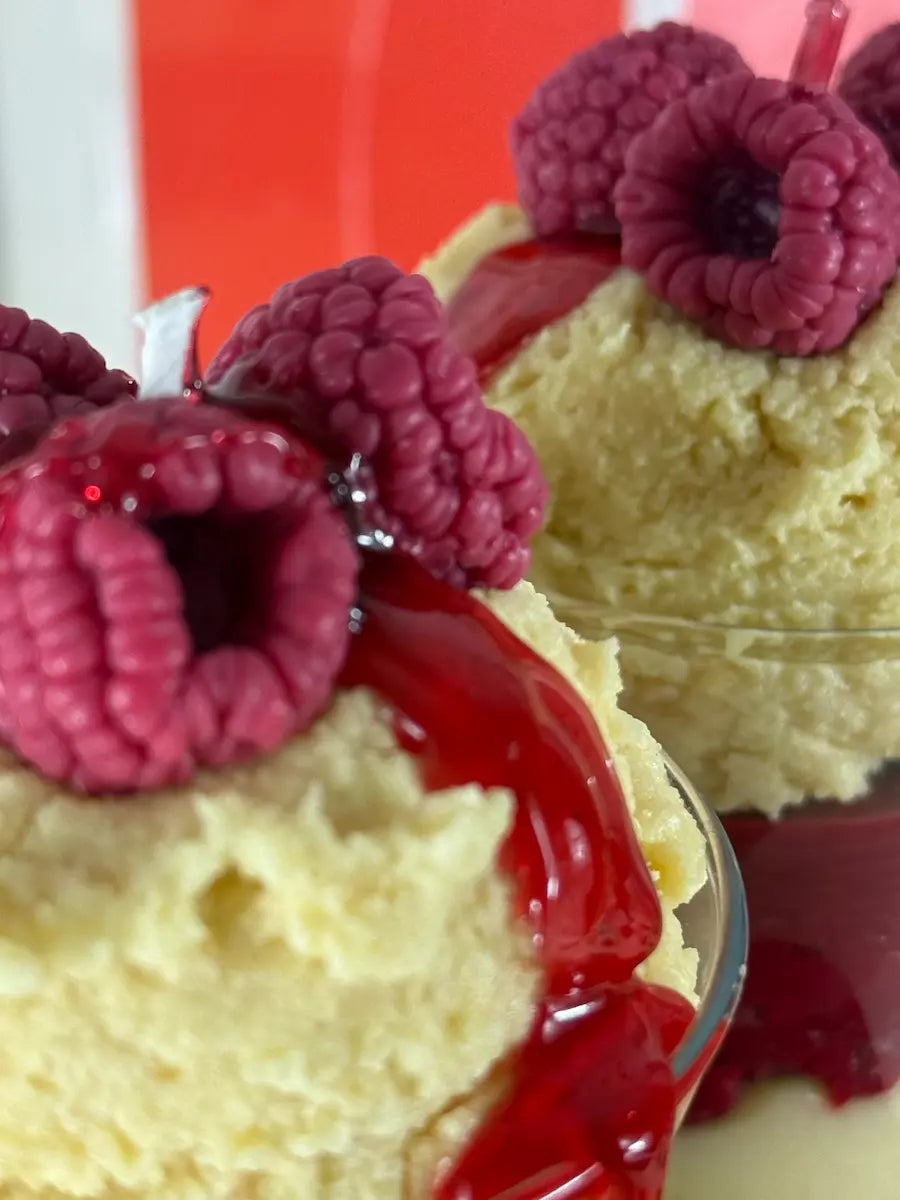 Nahaufnahme der Dessertkerze mit Vanille-Kugel, frischen Himbeer-Details und Himbeersauce – kramMITcharme