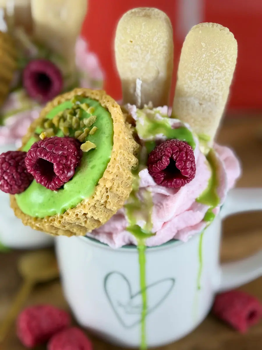 Nahaufnahme der Dessertkerze mit detailreichen Himbeeren, Pistazienoptik und zartem Rosé-Ton – kramMITcharme