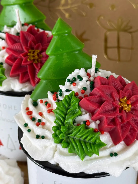 Nahaufnahme der Duftkerze „Holly Jolly Christmas Cup“ mit roten Weihnachtssternen und grünen Blättern aus Wachs – kramMITcharme