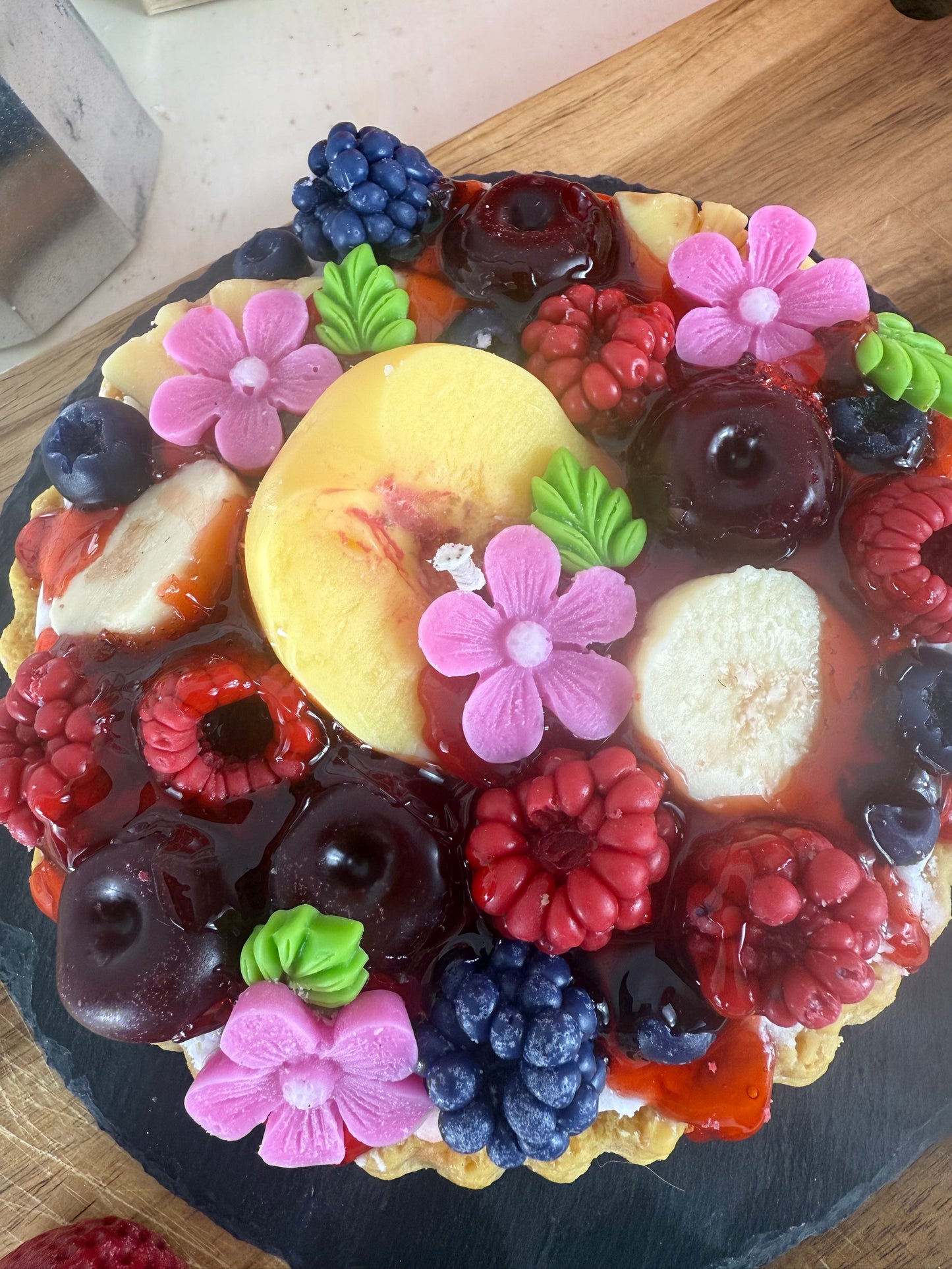 Detailaufnahme der Duftkerze „Juice-Club Cake“ mit realistischer Fruchtoptik und cremigem Wachs-Topping – kramMITcharme