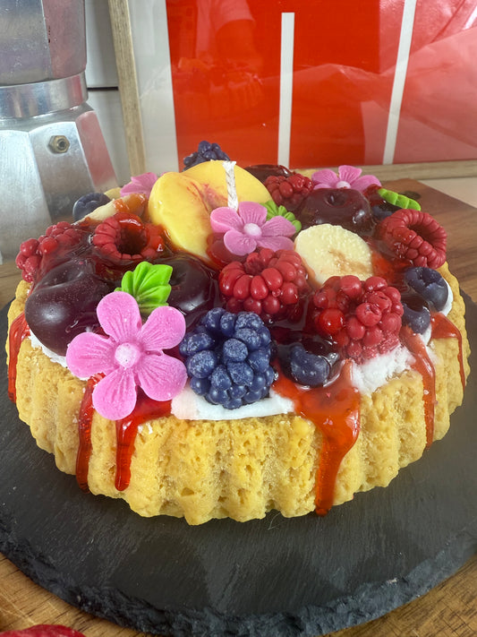 Nahaufnahme der Duftkerze „Juice-Club Cake“ mit Pfirsichscheiben, Beeren und violetten Blüten aus Wachs – kramMITcharme