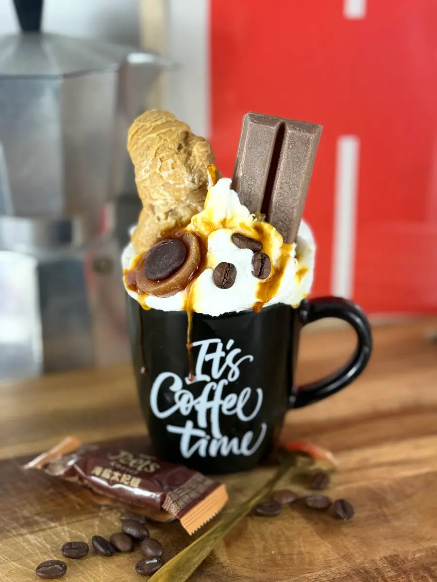 Handgemachte Coffee-Dessertkerze in schwarzer Tasse mit Karamell- und Schokoladendekor – kramMITcharme