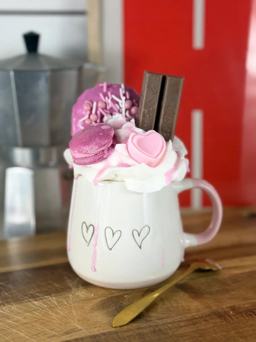 Handgemachte Dessertkerze in Kaffeetasse mit Sahneoptik, Herzmotiven, Macarons und Schokolade – kramMITcharme