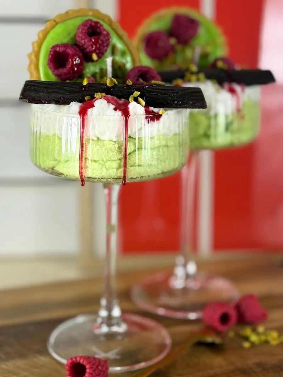 Detailaufnahme der Dessertkerze mit fließender Himbeersauce, Pistaziencreme und Schokoladendekor – kramMITcharme