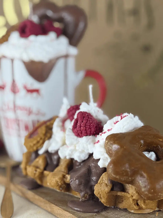 Detailaufnahme der Duftkerze „Santa’s Waffeltraum“ mit Schokoladenüberzug, Waffelstücken und cremiger Topping-Optik – kramMITcharme
