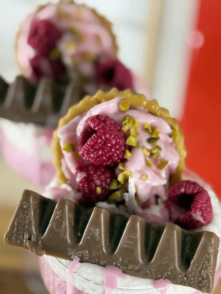 Detailaufnahme der Dessertkerze mit Schokolade, Himbeeren und Pistazienoptik im Glas – kramMITcharme