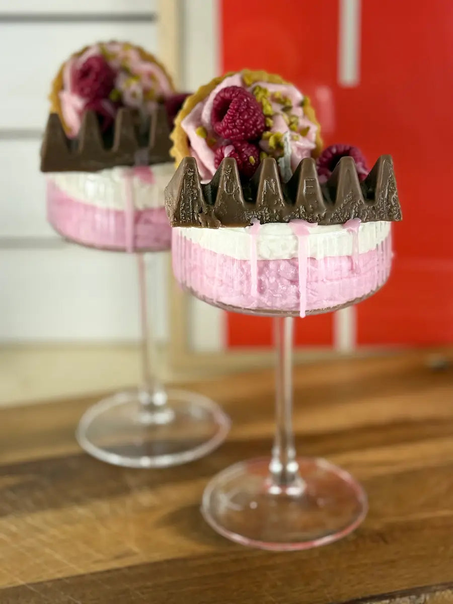 Handgemachte Dessertkerze im Glas mit rosafarbener Creme, Schokoschicht und Himbeer-Dekor – kramMITcharme