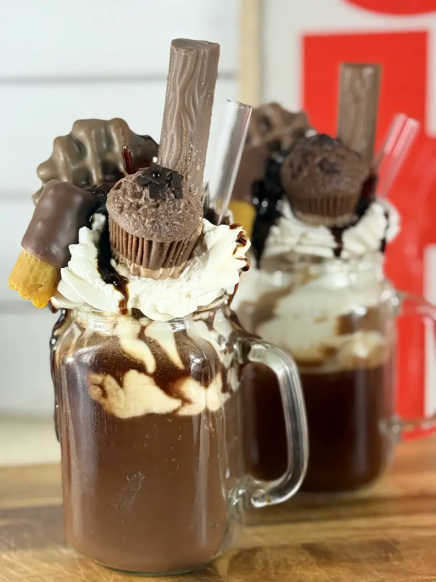 Handgemachte Schokoladen-Dessertkerze im Glasbecher mit cremigem Topping und Schokosauce – kramMITcharme