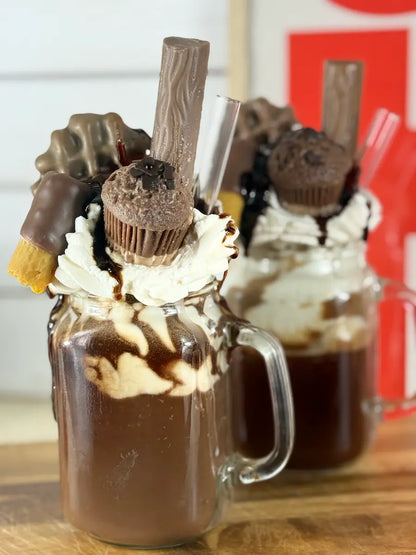Handgemachte Schokoladen-Dessertkerze im Glasbecher mit cremigem Topping und Schokosauce – kramMITcharme